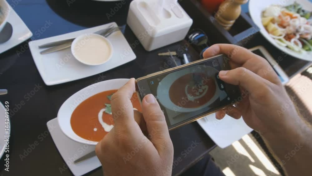 Man Taking Food Photo of Tomato Soup. Social Network Addiction Concept Man Taking Food Photo of Tomato Soup. Social Network Addiction Concept