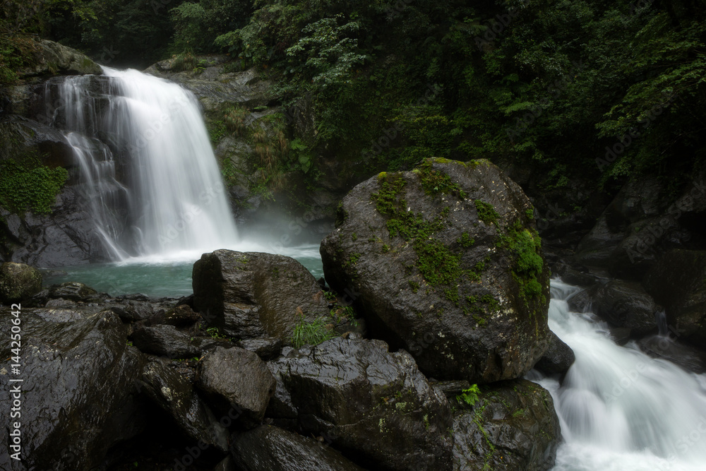 Wet rocks and waterfall at the Neidong National Forest Recreation Area in Wulai, Taiwan.