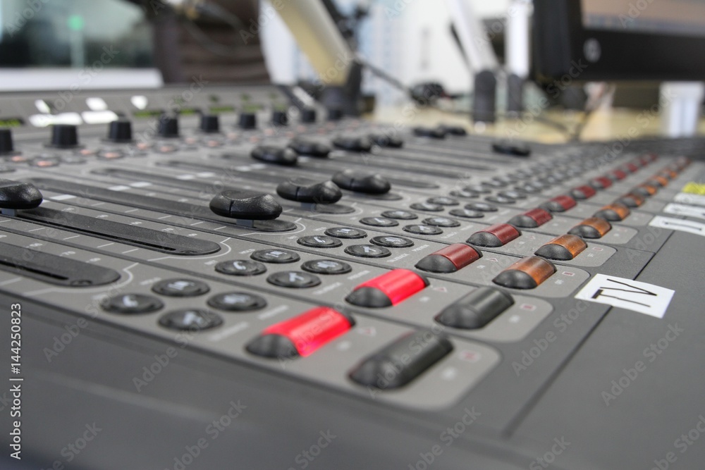 Professional audio operator working on audio mixer knobs during live TV telecast