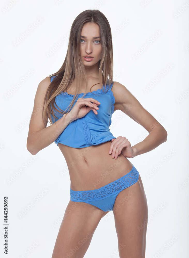 Fototapeta premium Slim tanned woman's body in lingerie over white background