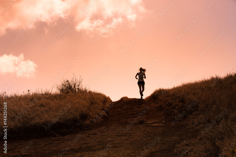 Silhouette of female running cross country. 