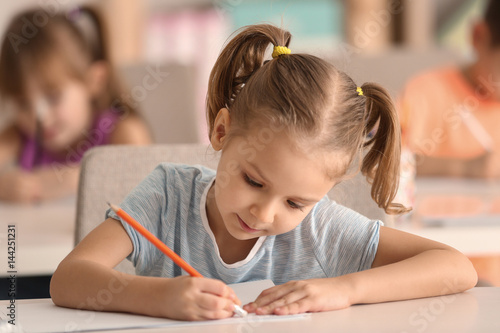 Cute girl drawing in classroom