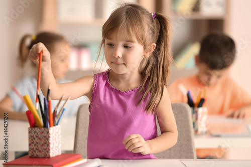 Cute girl at drawing lesson in classroom photo