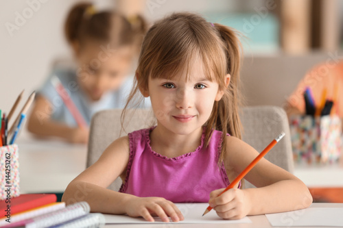 Cute girl drawing in classroom