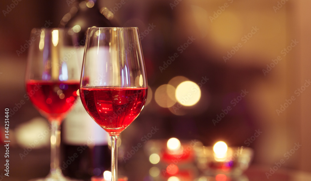 Wine glasses in a candle light dinner setting. Wine glasses in a candle light dinner setting.