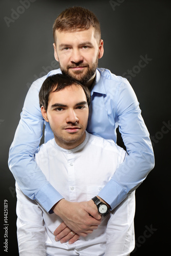 Happy gay couple on black b...