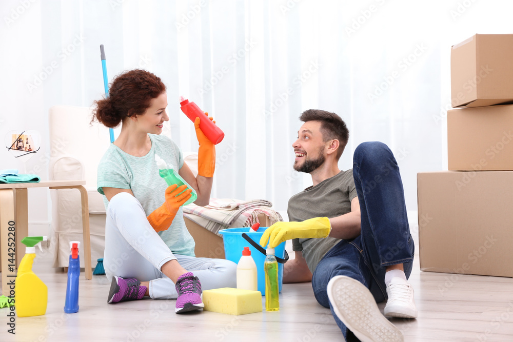 Happy young couple cleaning home together Happy young couple cleaning home together