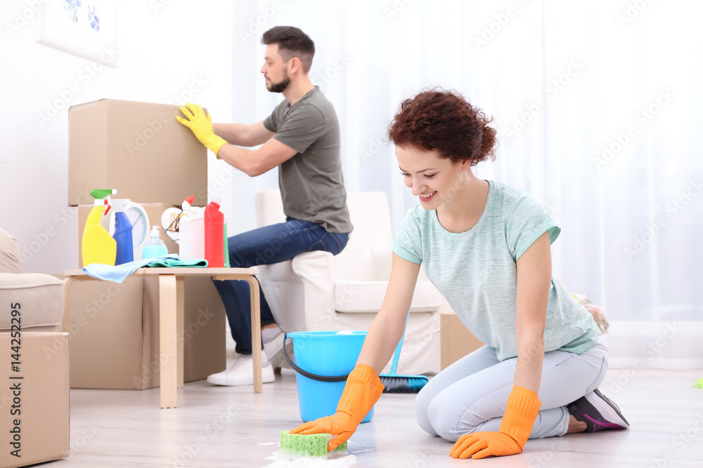 Happy young couple cleaning home together Happy young couple cleaning home together