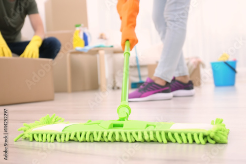 Woman moping floor in home, closeup