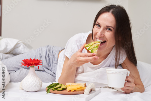 Brunette tasting sandwich with avocado