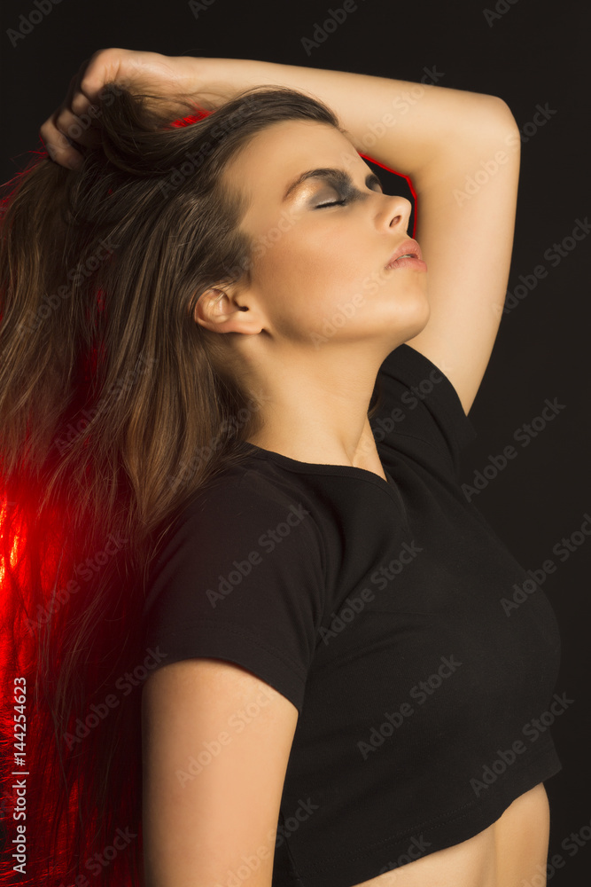 Naklejka premium Perfect brunette woman with art makeup at studio with red light