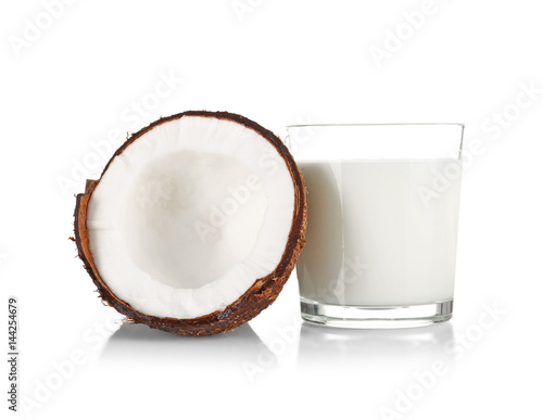 Glass of coconut milk with nut on white background photo