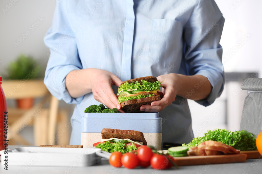 Mother packing meal for school lunch on table Mother packing meal for school lunch on table