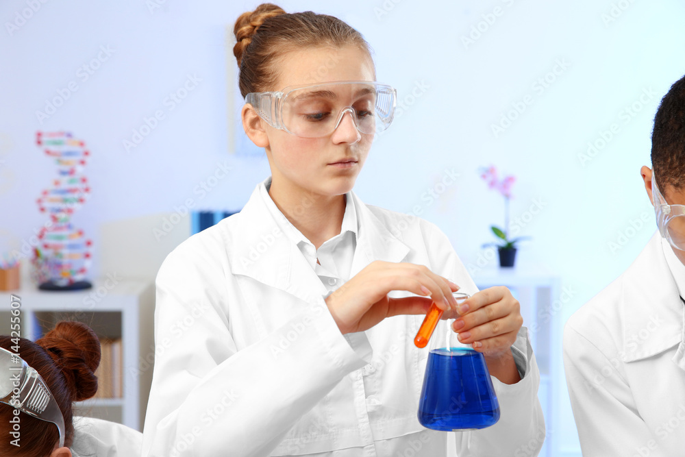 School girl making experiment in chemistry class School girl making experiment in chemistry class