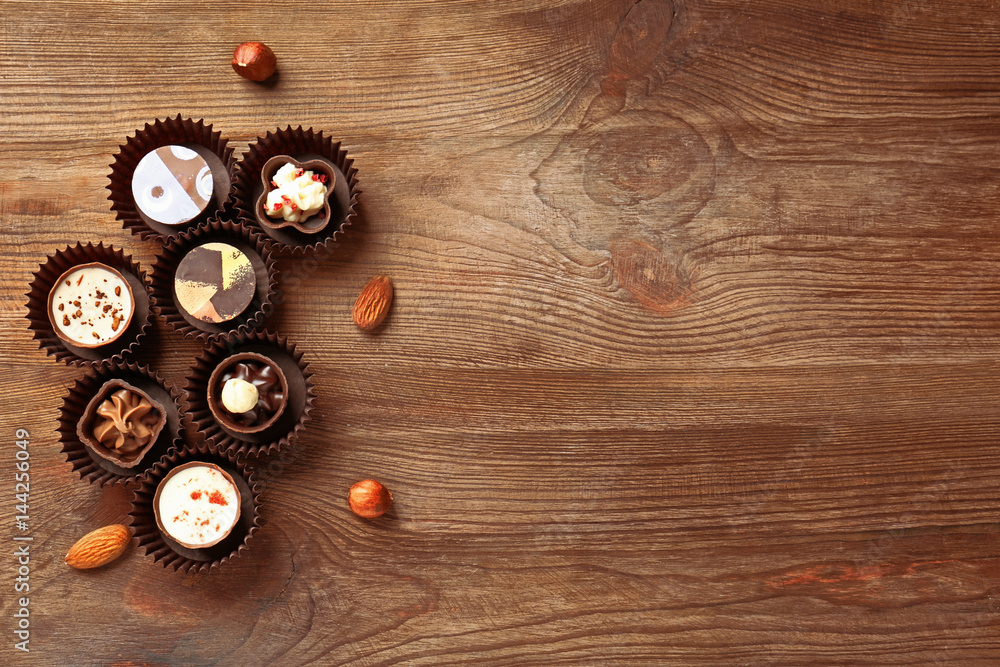 Delicious chocolate candies on wooden background Delicious chocolate candies on wooden background