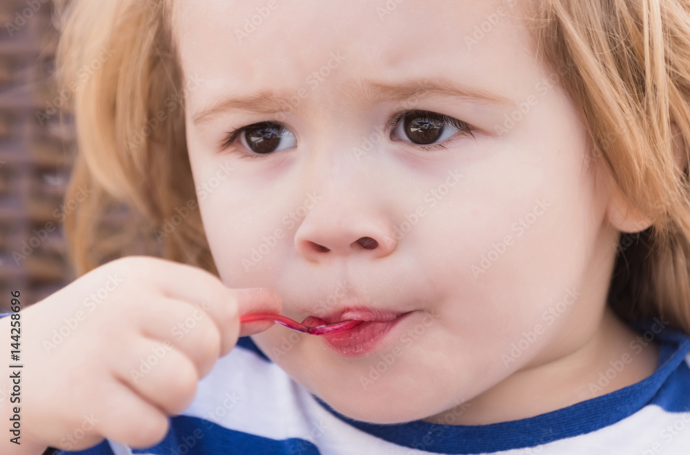 Cute baby boy eating tasty ice cream from spoon Cute baby boy eating tasty ice cream from spoon