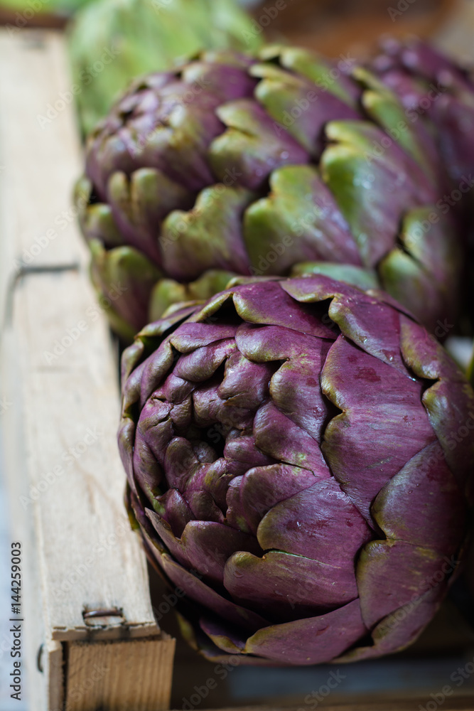 Fototapeta premium Fresh big Romanesco artichokes green-purple flower heads ready to cook