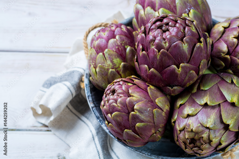 Fototapeta premium Fresh big Romanesco artichokes green-purple flower heads ready to cook