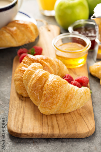 Freshly baked croissants with honey and jam