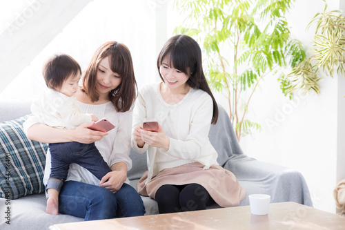 young asian family using smart phone in living room