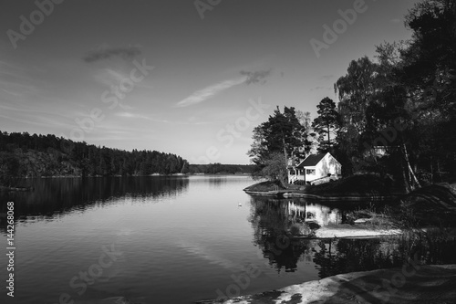white wooden house on the lake © Elizaveta