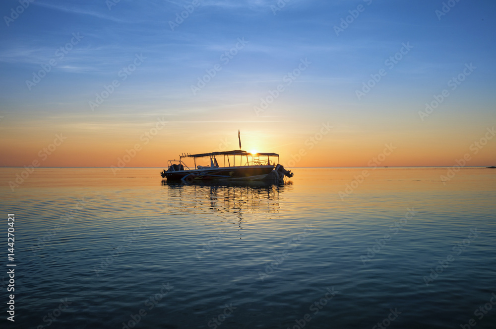 Two Excursion boats anchored againts the vibrant sunset by the shore of Simpang Mengayau, Kudat, Sabah.