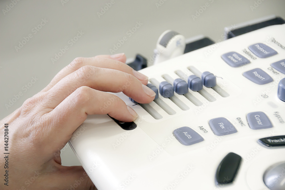 Hand of the doctor on the remote control of the uzi apparatus, medical equipment, doctor's hand Hand of the doctor on the remote control of the uzi apparatus, medical equipment, doctor's hand