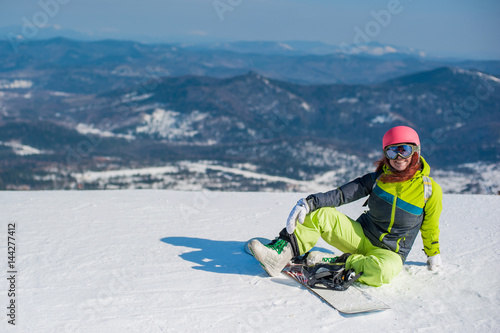 snowboarder in yellow clothes resting on the mountain