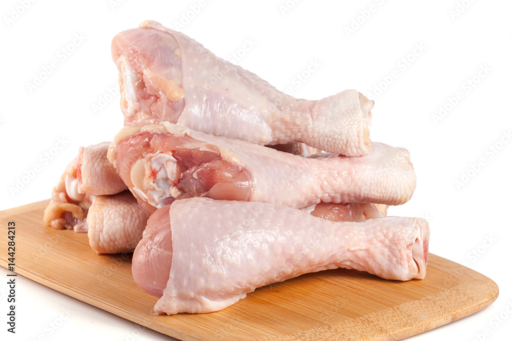 raw chicken drumsticks on a wooden cutting boardn white background raw chicken drumsticks on a wooden cutting boardn white background