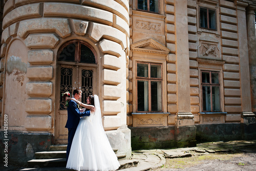 Wedding couple in love stay against old vintage palace.