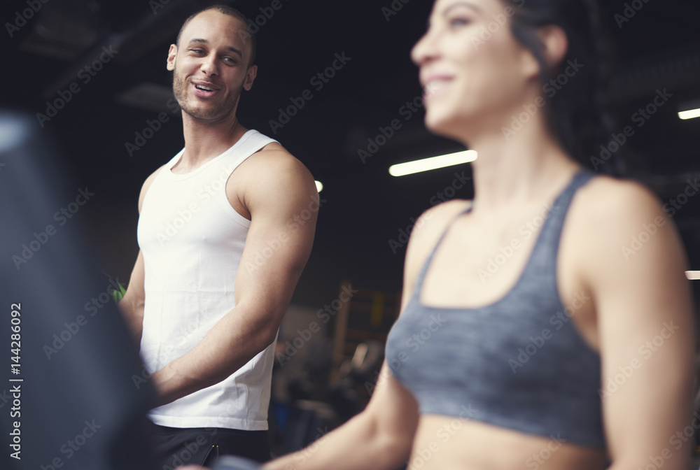 Young adult couple exercising on treadmill Young adult couple exercising on treadmill