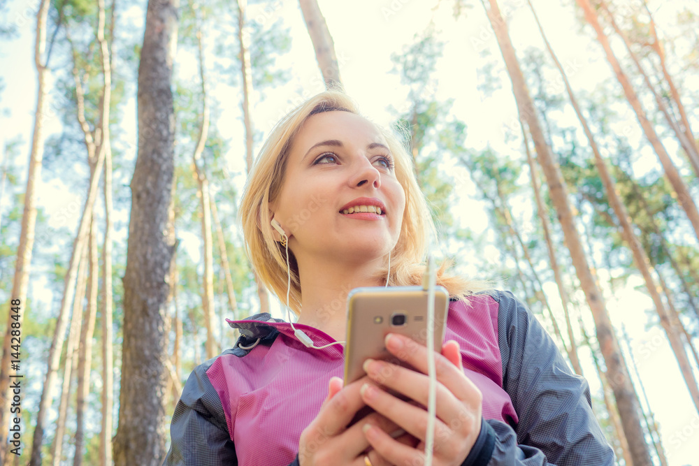 the girl athlete in the woods looking optimistic before holding the phone the girl athlete in the woods looking optimistic before holding the phone