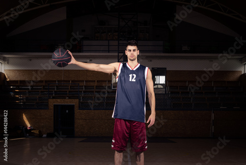 basketball player holding ball in one hand