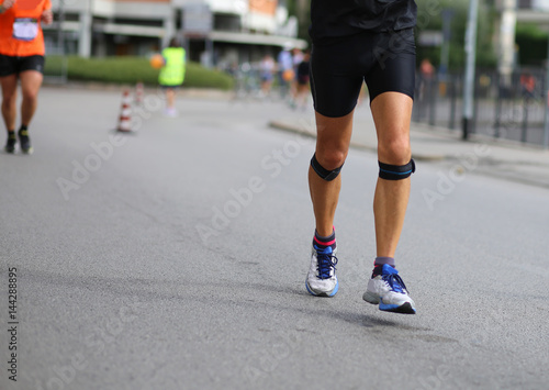 athlete running with bandage on his knees during the marathon