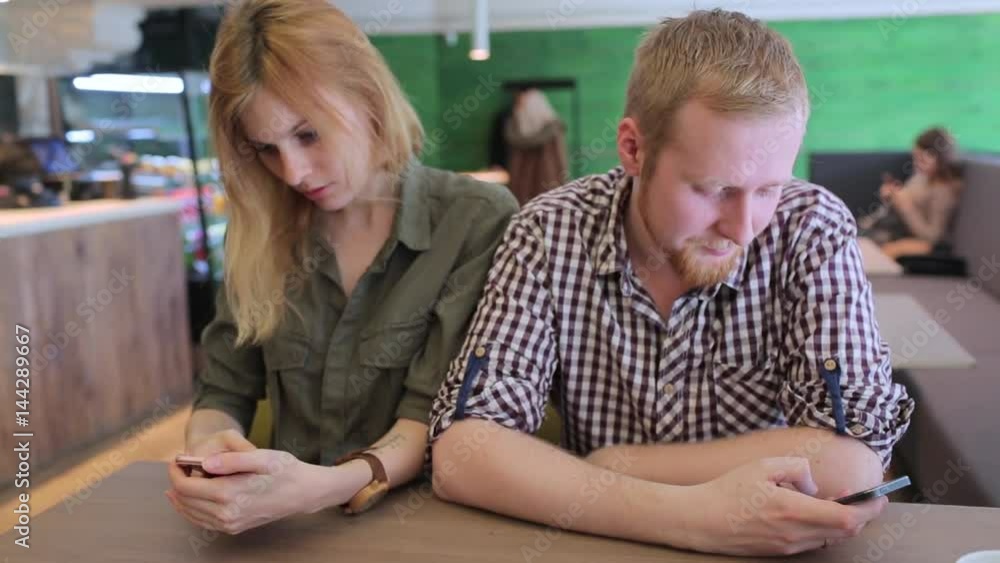 Angry couple, each with their phones Angry couple, each with their phones