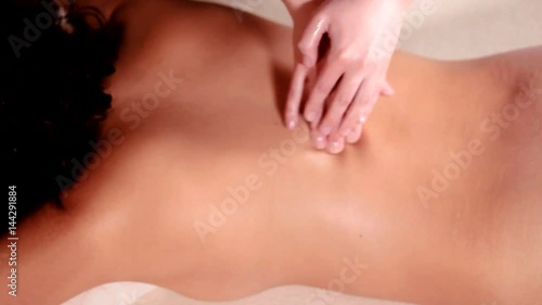 Beautiful young woman relaxing with hand massage at beauty spa close-up photo