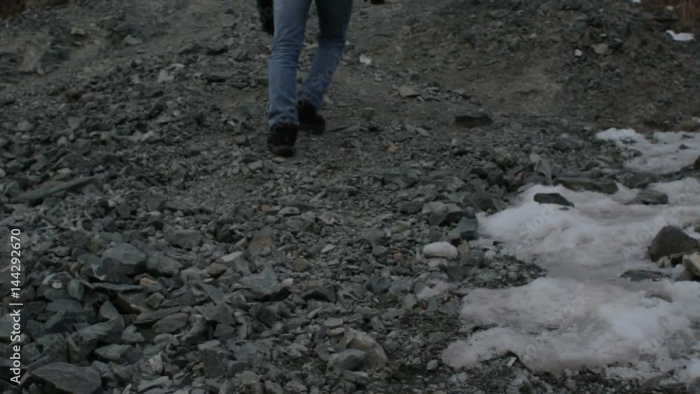Man wearing jeans and trekking shoes climbing a rocky trail Man wearing jeans and trekking shoes climbing a rocky trail