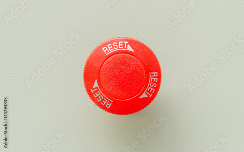 Red emergency stop and reset button on control panel for machine control. photo