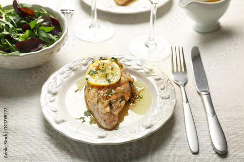 Plate with delicious chicken breast on table