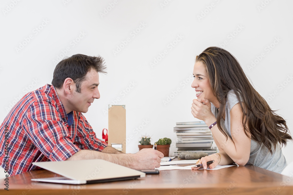 Morning scene. Two young colleagues in the office talk Morning scene. Two young colleagues in the office talk