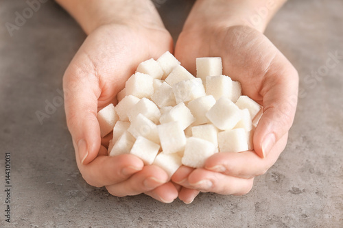 Female hands holding sugar cubes, closeup