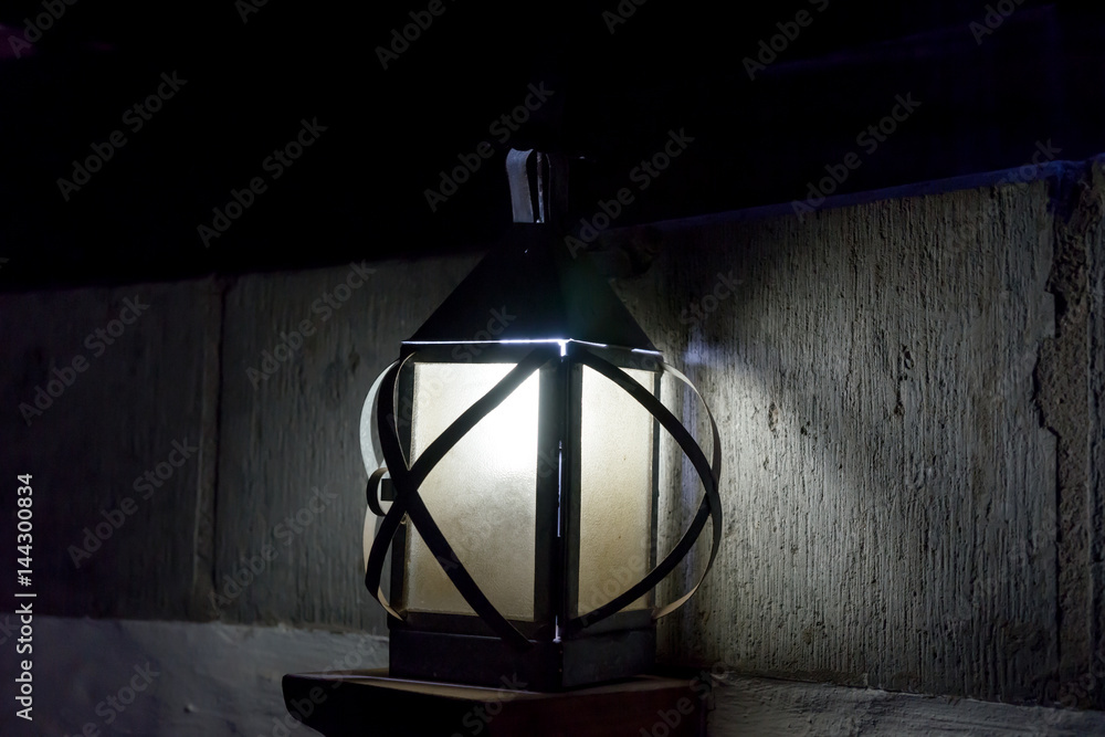Vintage old luminous lantern lamp in dark room