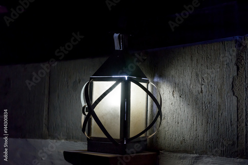 Vintage old luminous lantern lamp in dark room