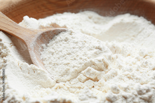 Taking wheat flour from bowl, closeup