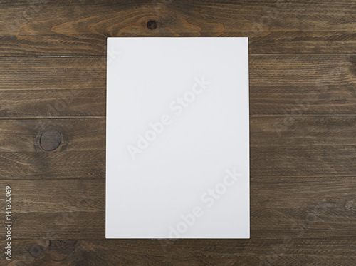 Blank sheet on brown wooden table. Horizontal shoot.