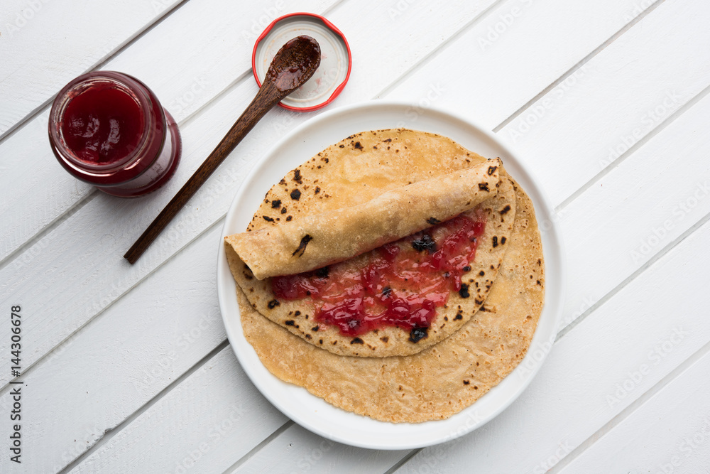 indian bread or chapati or paratha rolled with fruit jam, typical ...