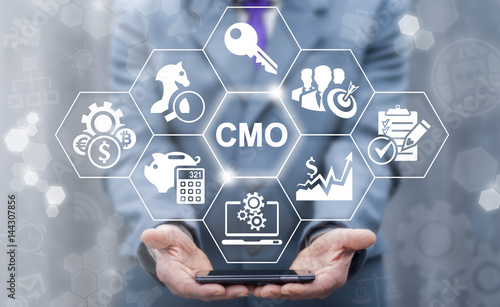 CMO - Chief Marketing Officer business shopping web store concept. Leadership internet shop mobile tech, finance, strategy office work. Businessman keep smart phone with cmo icon on virtual screen photo