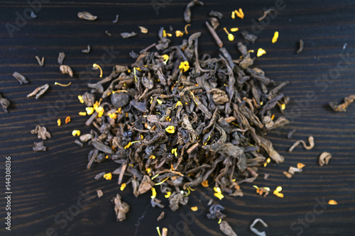 Tea and mixed forest fruits on a dark brown wooden Board.