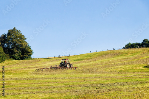 Tractor with plough doing some agricultural seasonal work in field