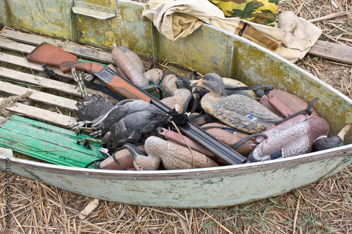 Fotografija Hunting boat with a hunting rifle and stuffed ducks